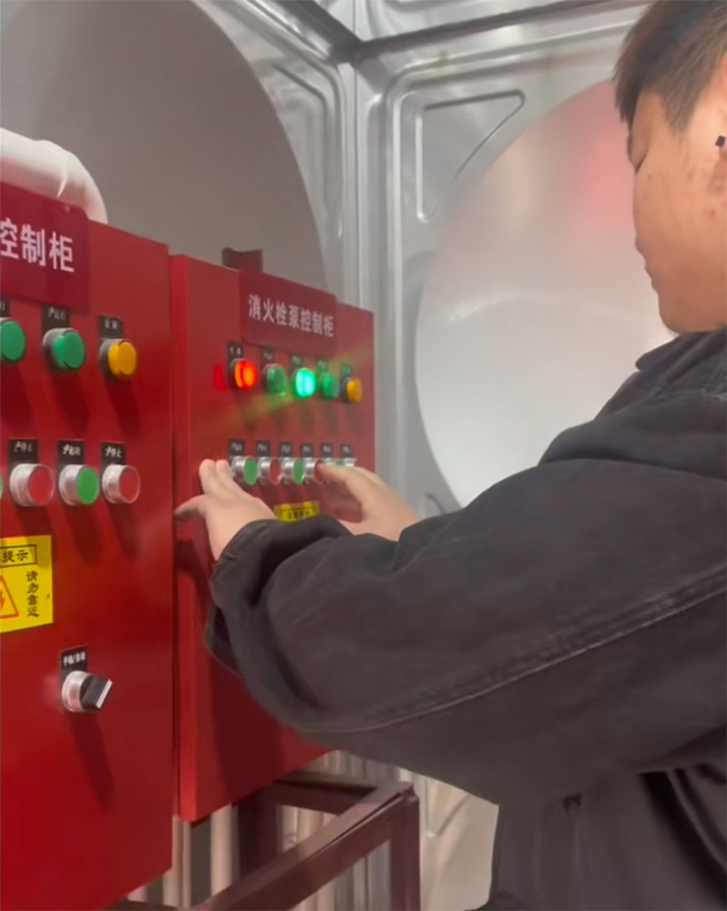 维保员在消防泵房操作控制柜，进行喷淋泵和消火栓泵的年度启停测试